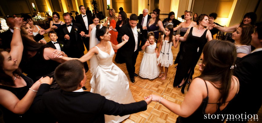 A bride dances in the middle of a circle of guests