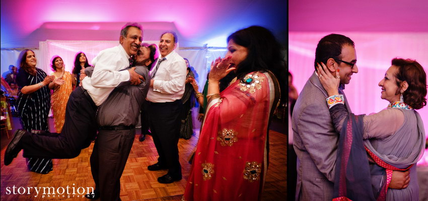 Family members laughing and dancing under pink tent lighting